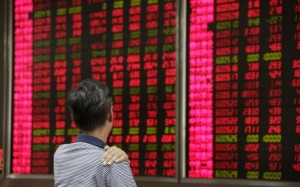 An investor looks at an electronic board showing stock information at a brokerage house in Beijing, August 27, 2015. China's turbulent stock markets rose on Thursday, helped by a strong rebound on Wall Street on expectations that the U.S. Federal Reserve will respond to days of China-led volatility by delaying an expected interest rate rise next month. REUTERS/Jason Lee