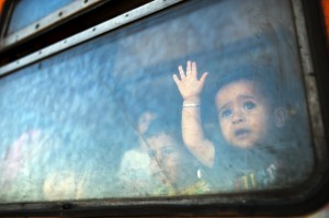 A migrant boy looks through a window onboard a train for Serbia at the new transit center for migrants at the border line between Greece and Macedonia near the town of Gevgelija on August 28, 2015. Serbia and Macedonia's foreign ministers called for EU action on Europe's migrant crisis at a summit on August 27 of leaders from the western Balkans, attended by German Chancellor Angela Merkel. Both have become major transit countries for tens of thousands of migrants trying to reach the European Union in recent months, with Macedonia last week forced to declare a state of emergency. AFP PHOTO / ROBERT ATANASOVSKI