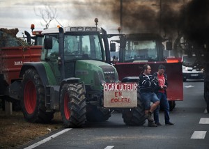 TOPSHOTS Farmers block the Oleron bridge linking Oleron Island with mainland France near Marennes on July 22, 2015. A wave of strikes across the country has escalated this week, in protest of raised prices on meat and dairy products that farmers say they have yet to benefit from and are now working at a loss. AFP PHOTO / XAVIER LEOTY