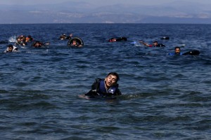 Refugee reacts from exhaustion while swimming towards the shore after a dinghy carrying Syrian and Afghan refugees deflated some 100m away before reaching the Greek island of Lesbos