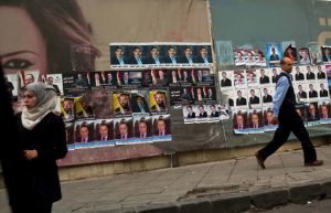 Syrians pass by campaign posters for parliamentary candidates in Damascus, Syria, Tuesday, April 12, 2016. Parliamentary elections will be held in Syria to elect the People's Council on 13 April 2016. The vote - expected to be a rubber stamp of President Bashar Assad's loyalists - will only proceed in government-controlled areas as the Damascus authorities are unable to organize any balloting in rebel-controlled areas or the territory under the Islamic State group. (AP Photo/Hassan Ammar)