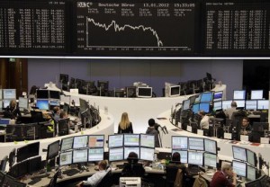 Traders are pictured at their desks in front of the DAX board at the Frankfurt stock exchange January 13, 2012.  REUTERS/Remote/Amanda Andersen  (GERMANY - Tags: BUSINESS)