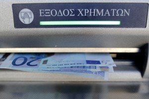 Sixty Euros, the maximum amount allowed after the imposed capital controls in Greek banks, are seen during a withdrawal operation at a bank branch ATM in central Athens, Greece, July 12, 2015. Skeptical euro zone finance ministers demanded on Saturday that Greece go beyond painful austerity measures accepted by Prime Minister Alexis Tsipras if he wants them to open negotiations on a third bailout for his bankrupt country to keep it in the euro.  REUTERS/Christian Hartmann  - RTX1K1WO