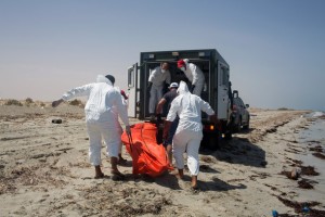 Workers for the Red Crescent carry the body of a dead migrant, in an orange body bag, to a nearby truck, at the waterfront in Zuwara, about 105 kilometers (65 miles) west of Tripoli, Libya, Friday, Aug. 28, 2015. Two ships went down Thursday off the western Libyan city, where Hussein Asheini of the Red Crescent said over 100 bodies had been recovered. About 100 people were rescued, according to the Office of the U.N. High Commissioner for Refugees, with at least 100 more believed to be missing. (AP Photo/Mohamed Ben Khalifa)
