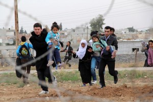 Syrians run as they flee from the Syrian town of Ras al-Ain to Turkish border town of Ceylanpinar, Sanliurfa province November 9, 2012. Around 9,000 Syrian refugees fled into Turkey in the past 24 hours, the U.N. refugee agency said on Friday, and Turkish state media said 26 defecting Syrian army officers had also arrived. More than 120,000 registered Syrian refugees are now sheltering in Turkish camps. Tens of thousands of unregistered Syrians are also living in Turkish border towns and villages. REUTERS/Stringer (TURKEY - Tags: POLITICS CONFLICT CIVIL UNREST)