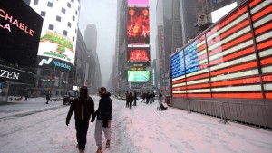 People walk through Times Square during winter blizzard that is expected to bring more than a foot of snow in New York, NY, on January 23, 2016. The National Weather Service and the Mayor of New York City have issued a winter storm warning for the five New York City boroughs. (Photo by Anthony Behar) *** Please Use Credit from Credit Field ***