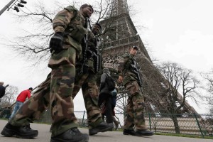 French soldiers patrol near the Eiffel Tower in Paris as part of the "Vigipirate" security plan December 23, 2014. French security forces stepped up protection of public places on Tuesday after three acts of violence in three days left some 30 wounded and reignited fears about France's vulnerability to attacks by Islamic radicals.  REUTERS/Gonzalo Fuentes (FRANCE - Tags: TRAVEL MILITARY POLITICS)