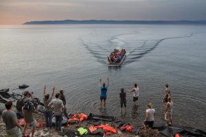 Press, volunteers and locals greet an inflatable boat carrying Syrian refugees as it arrives on the northern shore of the island of Lesbos in the evening. There is hardly any organised help for the refugees in Lesbos.  Volunteers from the UK, the Netherlands, Denmark and Norway are among the people who provide water, dry clothes and assistance for the newly arrived refugees. Around 2.000 refugees arrive on Lesbos island on most days.   The summer of 2015 saw a huge increase in the number of migrants and refugees arriving in Italy and Greece, wanting to enter the European Union and make their way to Northern Europe to find work or claim asylum. Greece has become a major transit country for people making the short crossing from the Turkish mainland to Greek islands near the Turkish coast.