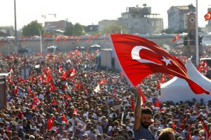 A man waves Turkey's national flag as he with supporters of various political parties gathers in Istanbul's Taksim Square