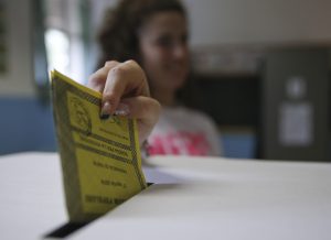 A woman casts her ballot for a referendum on the duration of offshore drilling concessions, in Pavia, Italy, Sunday, April 17, 2016. Italians are voting in a referendum on the duration of offshore drilling concessions in territorial waters, as nine regional governments seek to wrestle some influence over energy policy away from the central government in Rome. (AP Photo/Antonio Calanni)